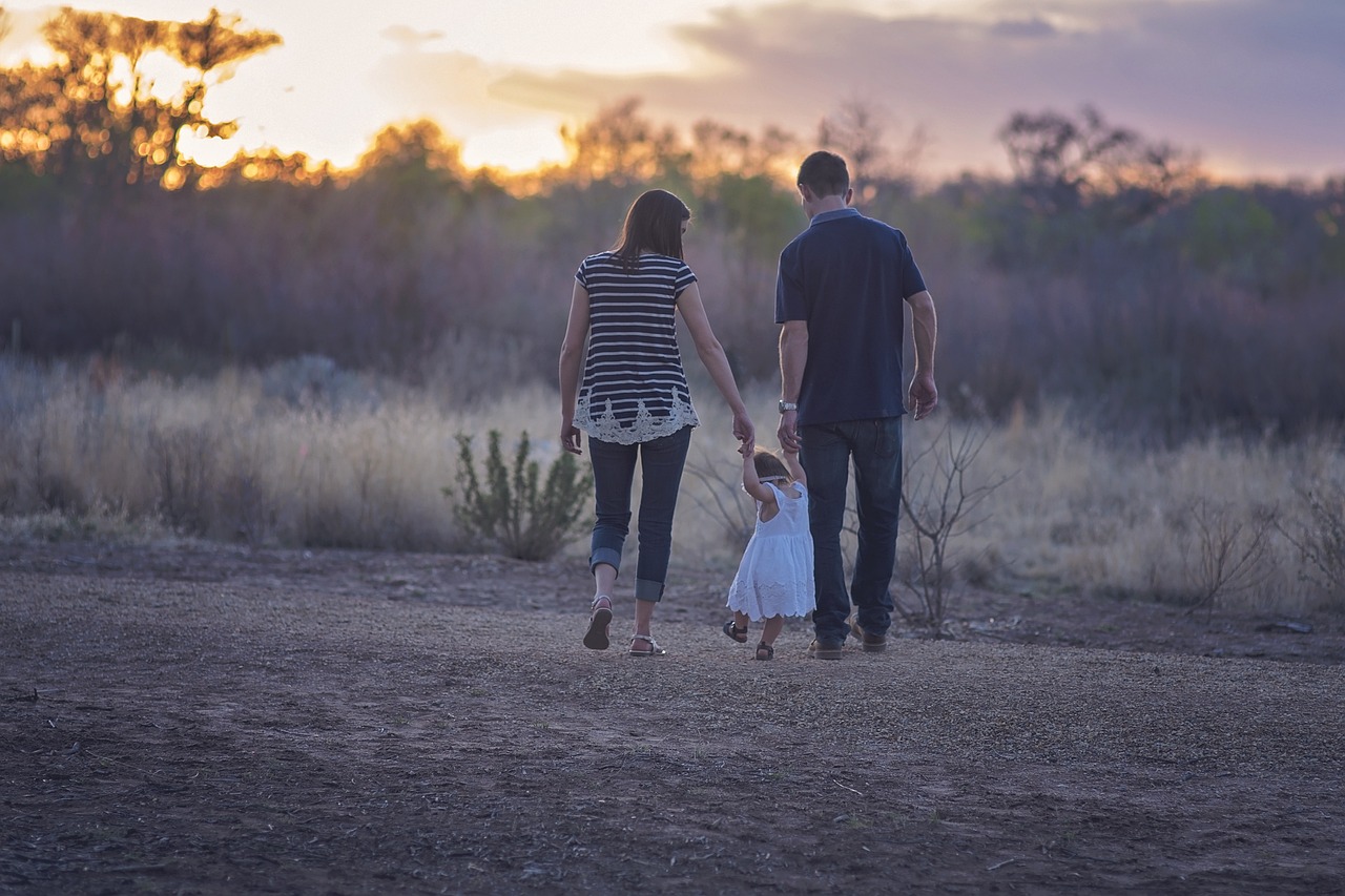 A mom and dad walking with a child